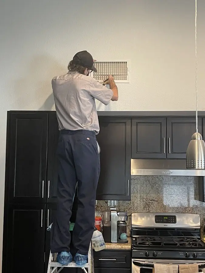 Technician inspecting an air vent during HVAC service in East Pasadena